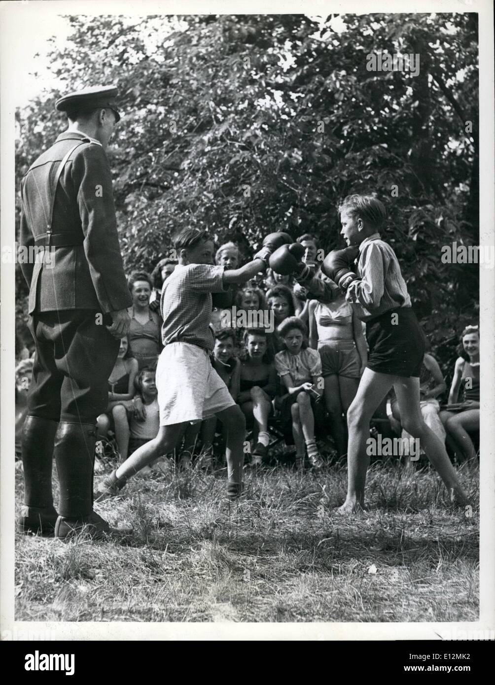 Febbraio 24, 2012 - un pubblico interessato due giovani pugili attirare una folla di ragazze, mentre il passaggio di un poliziotto tedesco si ferma a un arbitro. Foto Stock