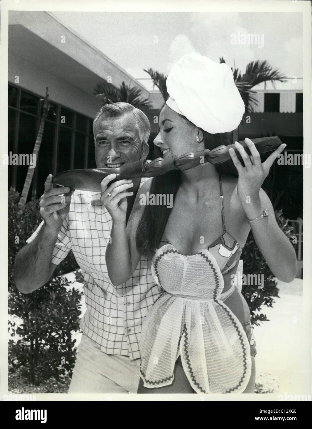 Febbraio 25, 2012 - capo allenatore di calcio Ray tombe presso la University of Florida sembra essere la cottura di una birra speciale con shapely Sunken Gardens modello Candy Sugarek da San Pietroburgo, Florida, per Gator il primo scontro con la United States Air Force Academy in settembre. Candy è davvero un dolce strega da est e lei sostiene che non è mai troppo presto per preparare il suo Gator andare succo che è garantito per rendere Gators lotta'n mad. Foto Stock