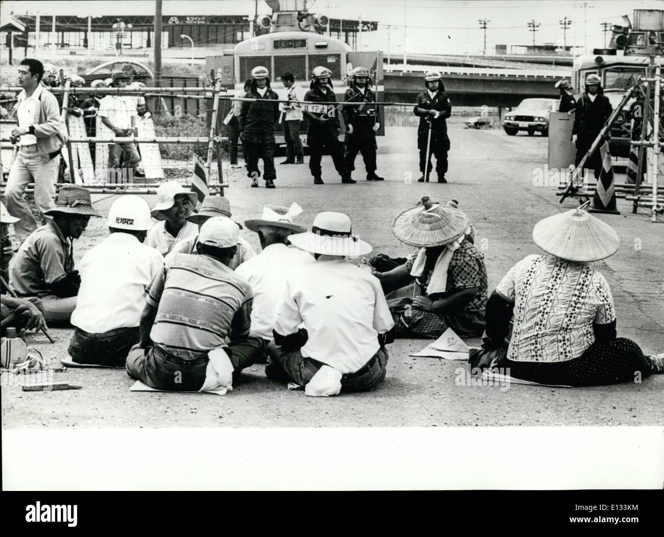 Febbraio 26, 2012 - Dimostrazioni a Tokyo il nuovo aeroporto internazionale: gli agricoltori sindacalisti e studenti, 2000 in tutti ha preso parte a una dimostrazione protestando contro il nuovo Aeroporto Internazionale di Narita di Tokyo. Hanno bruciato copertoni usati rendendo le nuvole di fumo nero che è andato alla deriva in tutta la pista sperando di fermare i grandi getti da di atterraggio e di decollo durante i voli di collaudo del nuovo aeroporto, che spero diventerà operativo nel 1978. La foto mostra gli agricoltori tenendo un sit-in davanti al Gate airport-in background della polizia guardia. Foto Stock