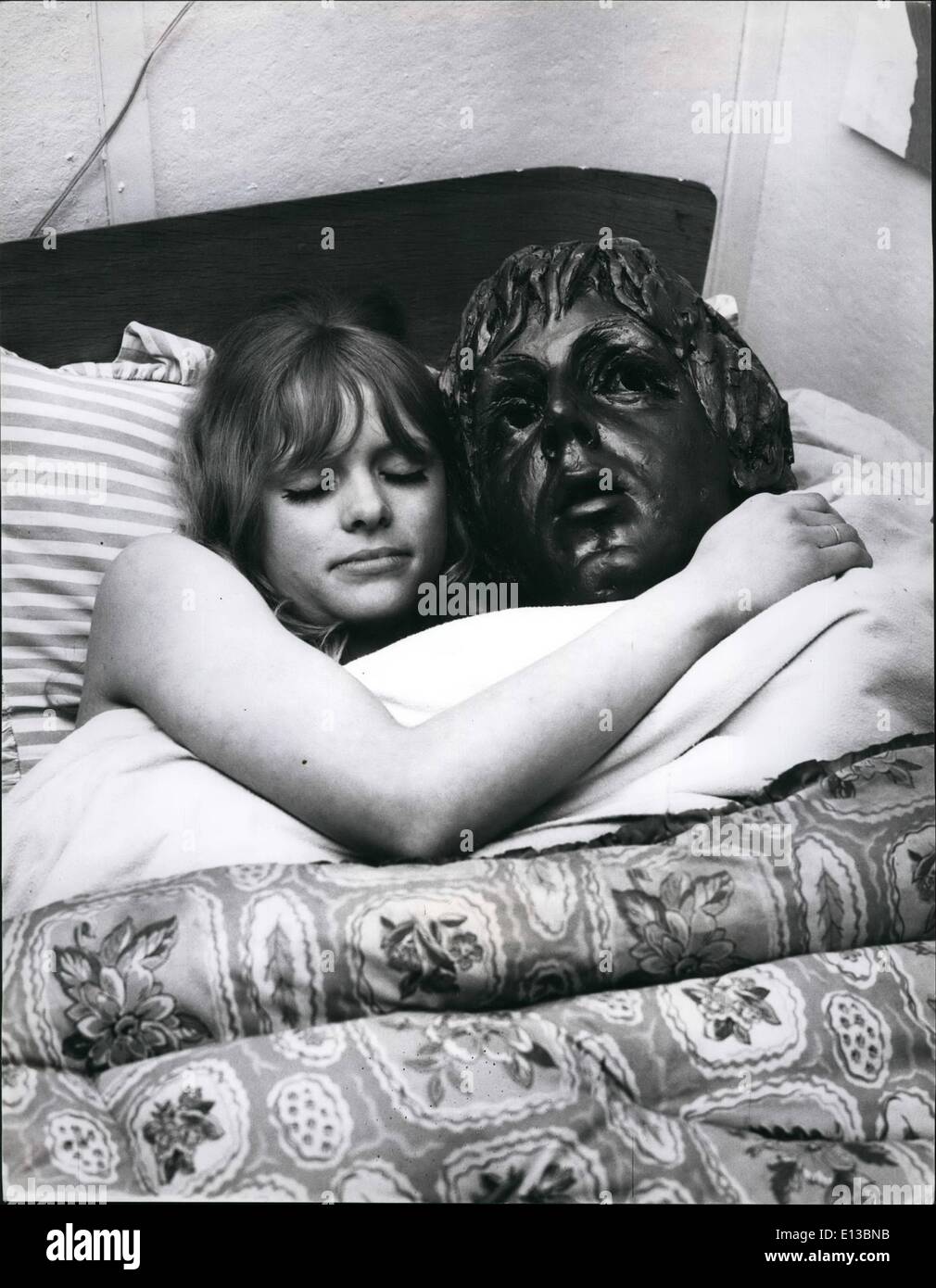 Febbraio 29, 2012 - Beatling avanti.: Lotti e lotti di ragazze sono Beatle fan, ma c'è qualcosa di Luz Moore (21) di Ashstead, SUrrey può fare circa la sua mania - lei può fare la sua propria Beatles. Liz è un esperto scultore e è stata la modellazione di dimensione di vita i busti di quattro famosi nel suo studio. Una bella bionda, Liz crede in indossando il più idoneo "ingranaggio" per il suo lavoro che ottiene abbastanza caldo a volte e coinvolge un sacco di polvere. Quando il nostro fotografo invita Liz a casa sua era occupato in un busto di Beatle John. La foto mostra ragazza nel letto con un Beatle Foto Stock