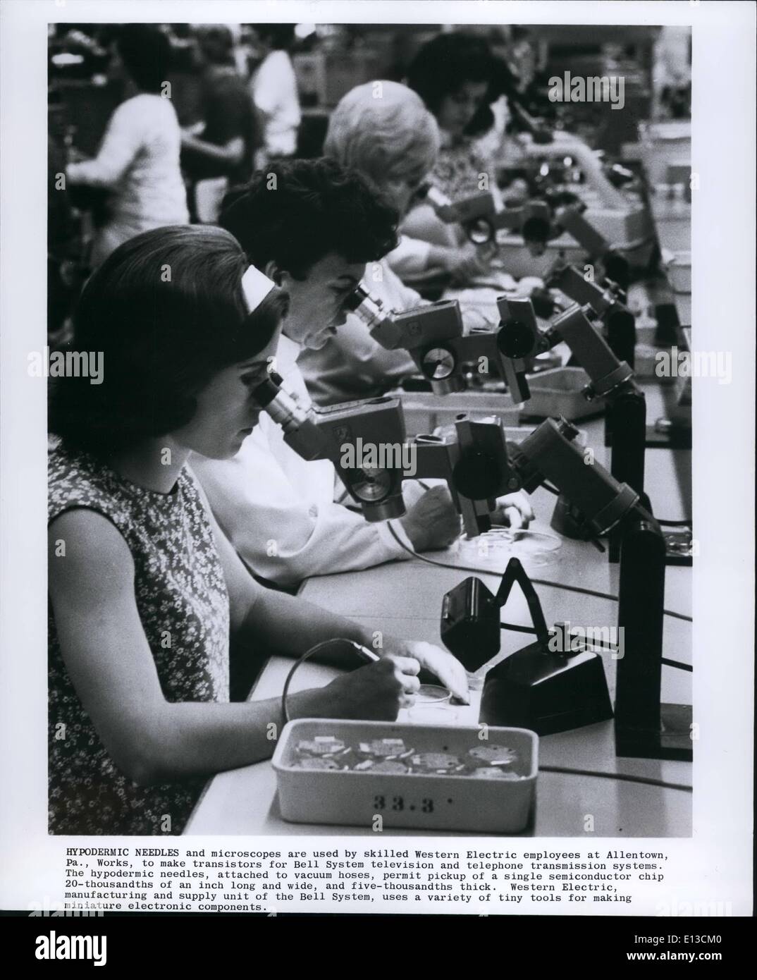 Febbraio 29, 2012 - aghi ipodermici e microscopi sono utilizzati da esperti Western Electric dipendenti a Allentown, Pa. lavora per rendere transistori per sistema a campana la televisione e il telefono del sistema di trasmissione. Gli aghi ipodermici, collegato con i tubi di vuoto, consentono il prelievo di un singolo chip a semiconduttore 20 millesimi e unità di alimentazione del sistema a campana, utilizza una varietà di piccoli utensili per la realizzazione di componenti elettronici miniaturizzati. Foto Stock