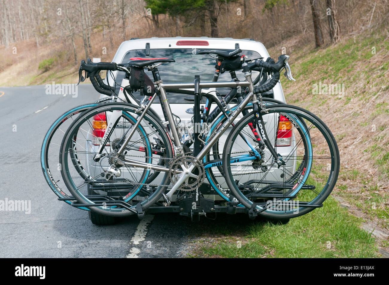 Bici da Strada montati su una cremagliera fissata alla parte posteriore di un SUV. Foto Stock