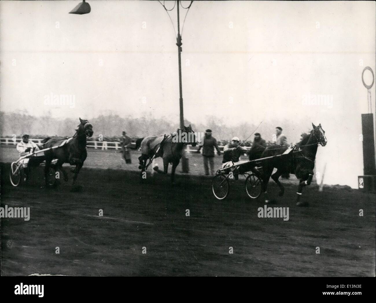 Mar 02, 2012 - Zampetto Crash durante una gara a Vincennes Paris: durante la gara di trotto per l'argentino Cup a Vincennes, Parigi tre concorrenti si sono scontrate e si è schiantato senza dubbio a causa del ghiaccio della pista. Nessuno dei piloti sono stati male ma i cavalli erano giù e arrotolato. Dalle tribune lo sguardo disasterious. I tre cavalli coinvolti sono stati ''Eboue Wilkers'' che in cambio di traiettoria per evitare un altro portato giù ''Estelle IV'' che a sua volta spinto oltre ''Darius II". La foto mostra il vincitore che passa il post, il cavallo. Al galoppo allentato è ''Estelle IV'' trascinando ciò che rimane del suo sulky. Foto Stock