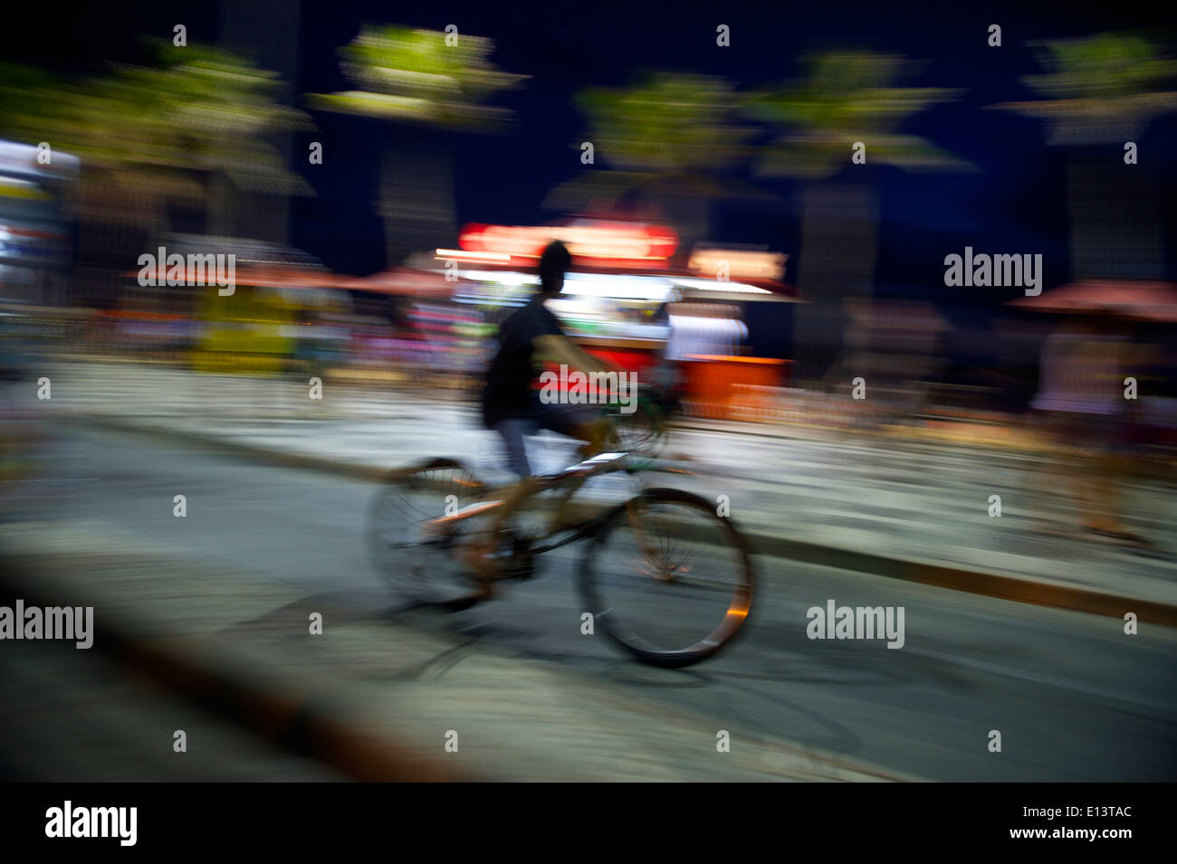 Il brasiliano in sella ad una bicicletta sulla spiaggia di Ipanema percorso ciclistico di Rio de Janeiro in Brasile di notte Foto Stock