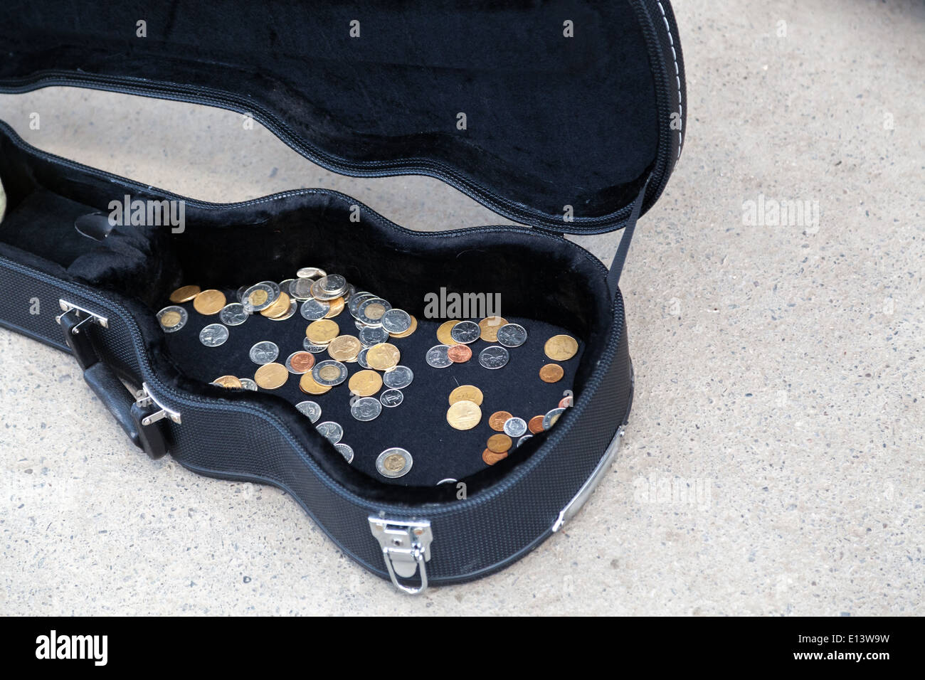Le monete in un caso di chitarra in una strada Foto Stock