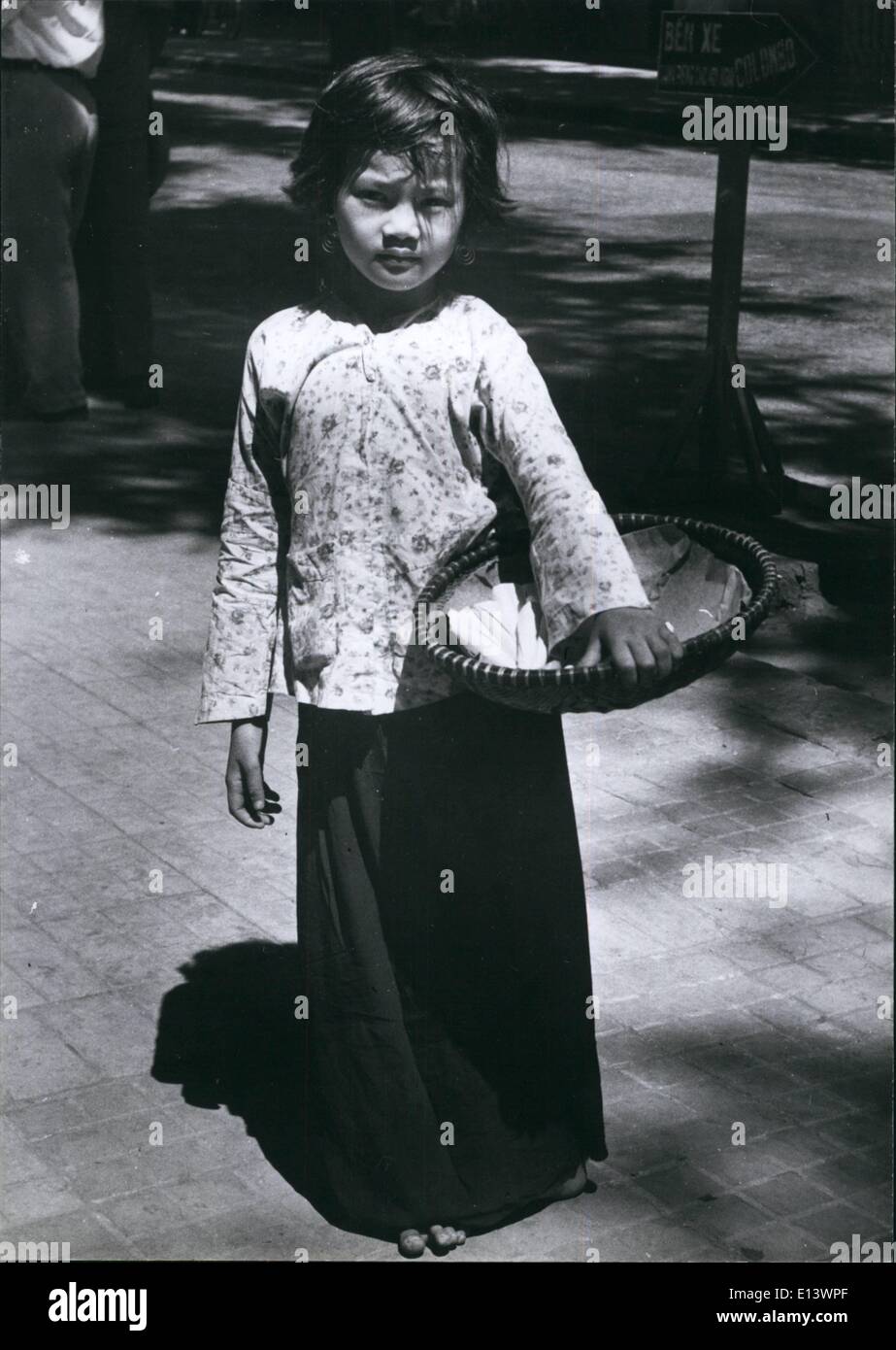 27 mar 2012 - Solo un bambino, ma lei è fuori dalla mattina a mezzanotte vende noccioline per le strade di Saigon. Foto Stock