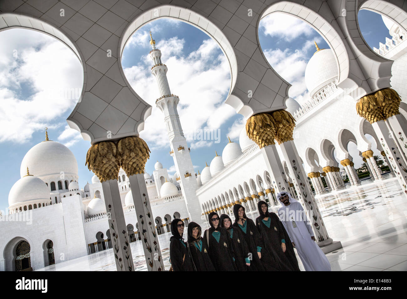 Emirati Arabi Uniti, Abu Dhabi Sheikh Zayed Grande moschea. Gruppo di turisti, vestito conforme al codice di abbigliamento, scattare una foto Foto Stock