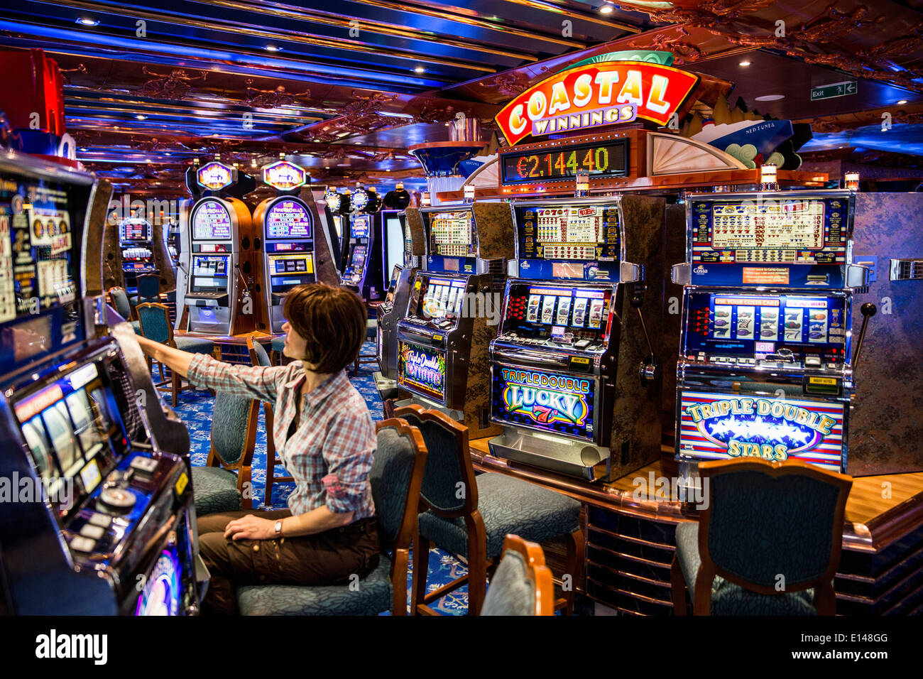 Emirati Arabi Uniti Dubai, nave da crociera Costa Fortuna, società dall'Italia. Gambling Hall. Donna che gioca slot machine Foto Stock