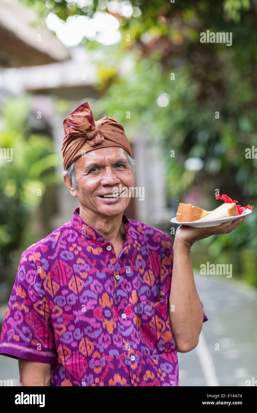 Server Balinese portante la lastra di cibo Foto Stock