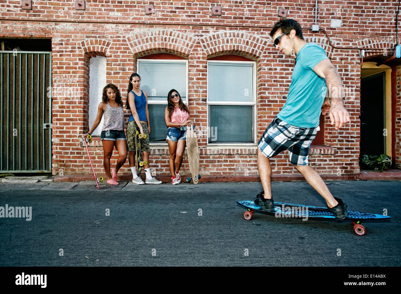 Amici longboards equitazione sulla strada di città Foto Stock