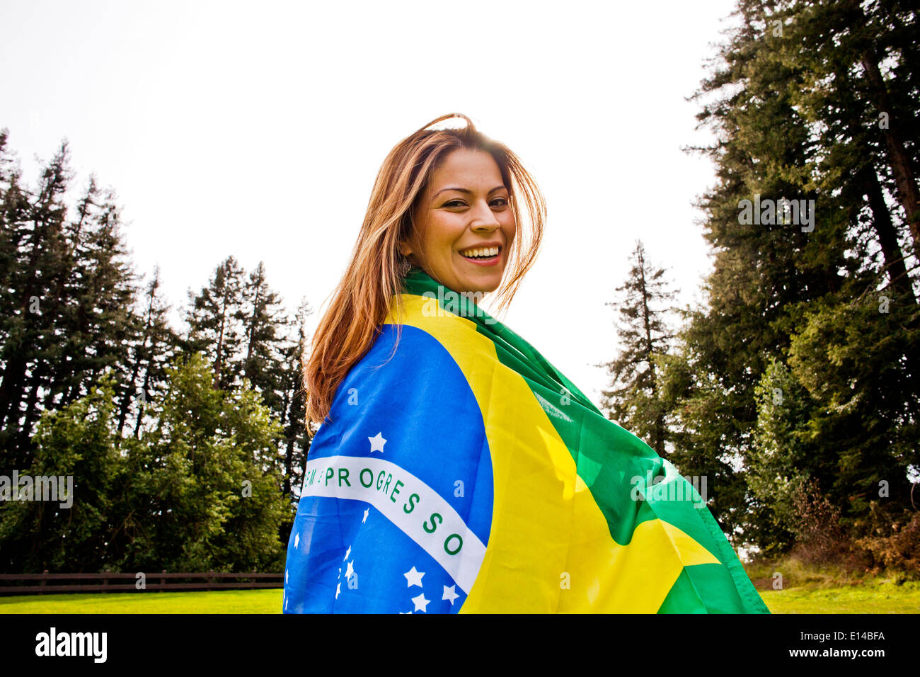 Ispanico donna avvolta nella bandiera brasiliana Foto Stock