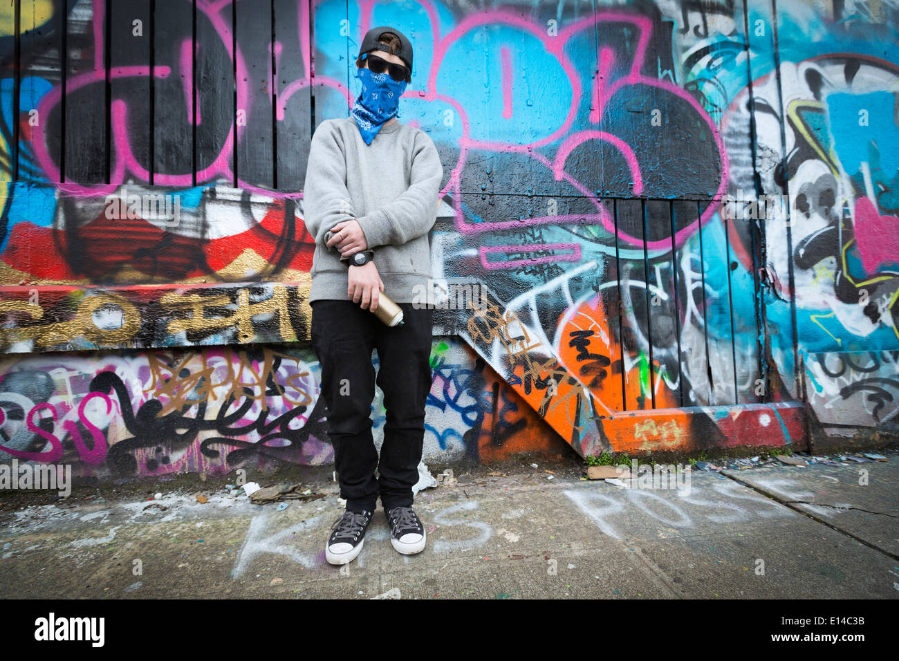 Caucasian ragazzo adolescente in piedi dal muro di graffiti Foto Stock