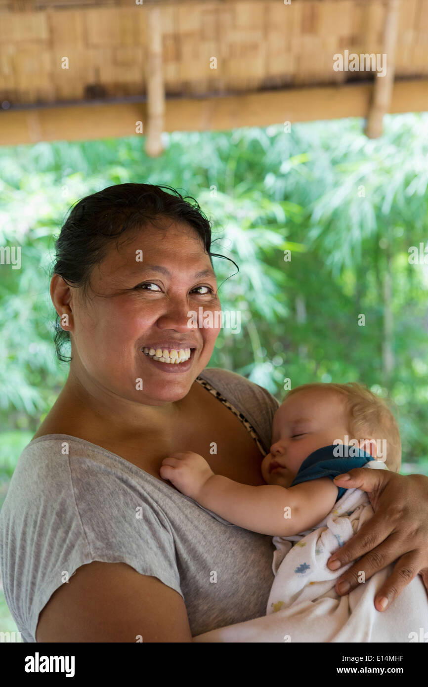 Sorridente babysitter cullano baby Foto Stock
