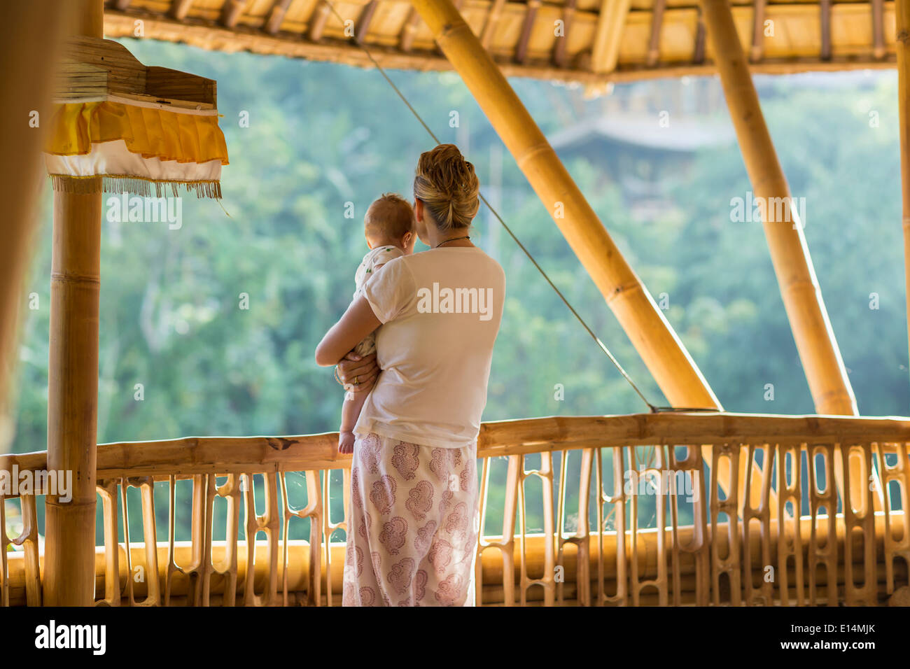 Caucasian la madre e il bambino che si affaccia la vista dal balcone Foto Stock