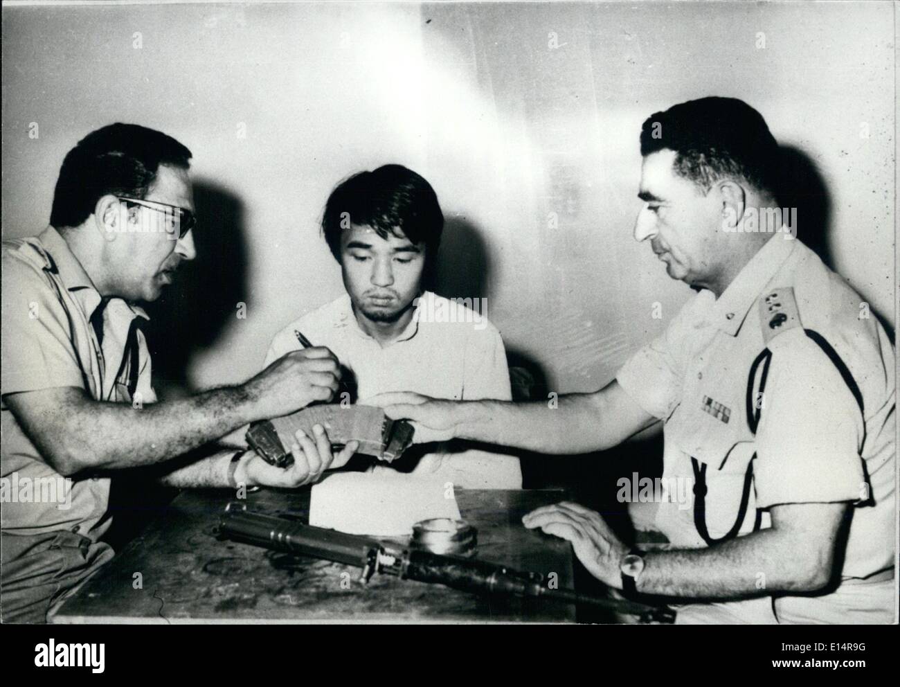 Apr. 18, 2012 - Okamoto suscettibili di essere giudicati dal tribunale militare: il terrorista giapponese Kozo Okamoto puntando verso il magazzino ha usato al massacro di Lod, nel corso della sua inchiesta. (Destro, funzionario di polizia E. Goldberg - sinistra funzionario di polizia M. Golan). Sul tavolo è la ceca paracadutista leggero fucile utilizzato nel massacro. Foto Stock