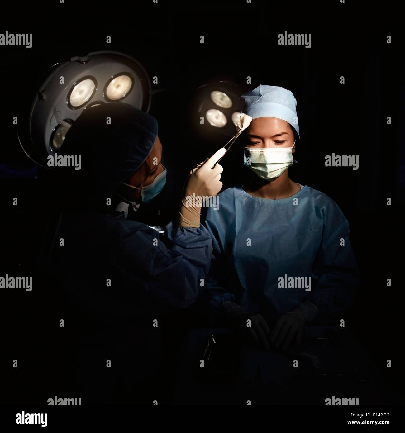 Infermiera caucasica tergi sudore dal chirurgo la brow Foto Stock
