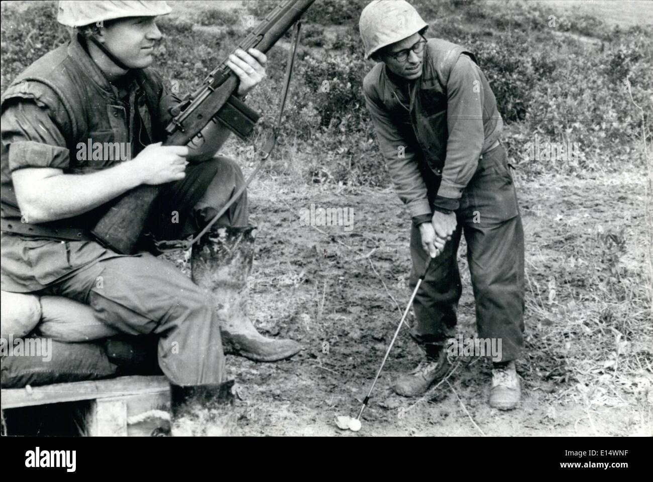 Apr. 18, 2012 - Avanti!!! Un U.S. Army officer ottiene in pochi colpi di pratica con la sua golf club, durante una Iull nella lotta seguente operazione Chinook 11 in Vietnam. Anche se il corso era ruvida e rischioso, riuscì ad ottenere in qualche buon oscilla mentre un rifleman veglia su di lui. Foto Stock