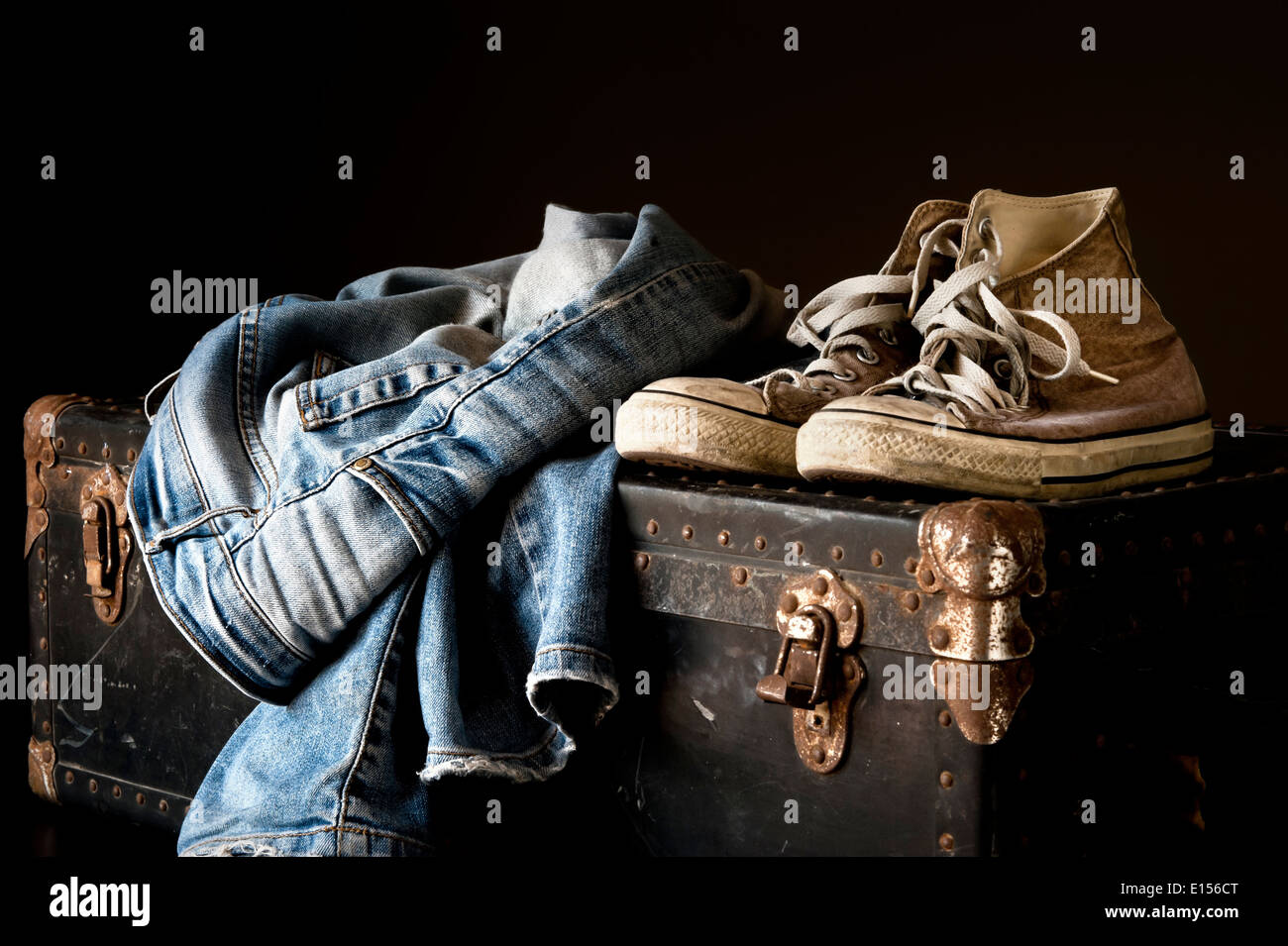 Paio di jeans e scarpe da ginnastica su una valigia vintage Foto stock - Alamy