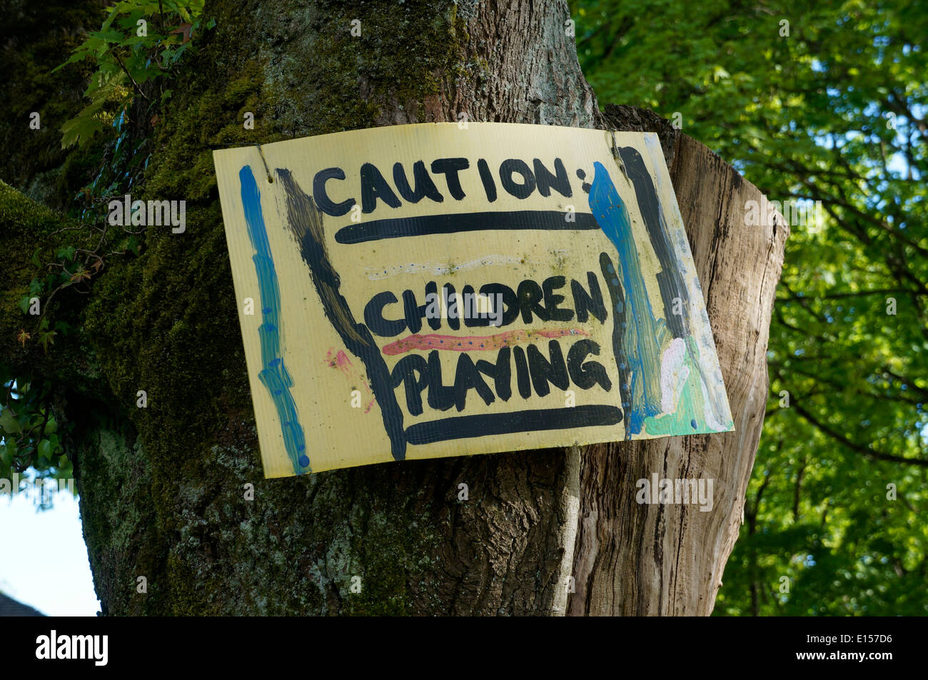 Dipinte a mano e i bambini giocando segno attaccato a un albero Foto Stock