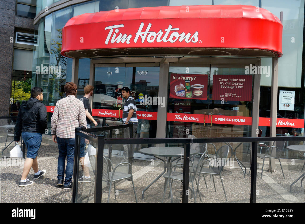 Giovani uomini di entrare a Tim Hortons caffetteria e ristorante in Vancouver, BC, Canada Foto Stock