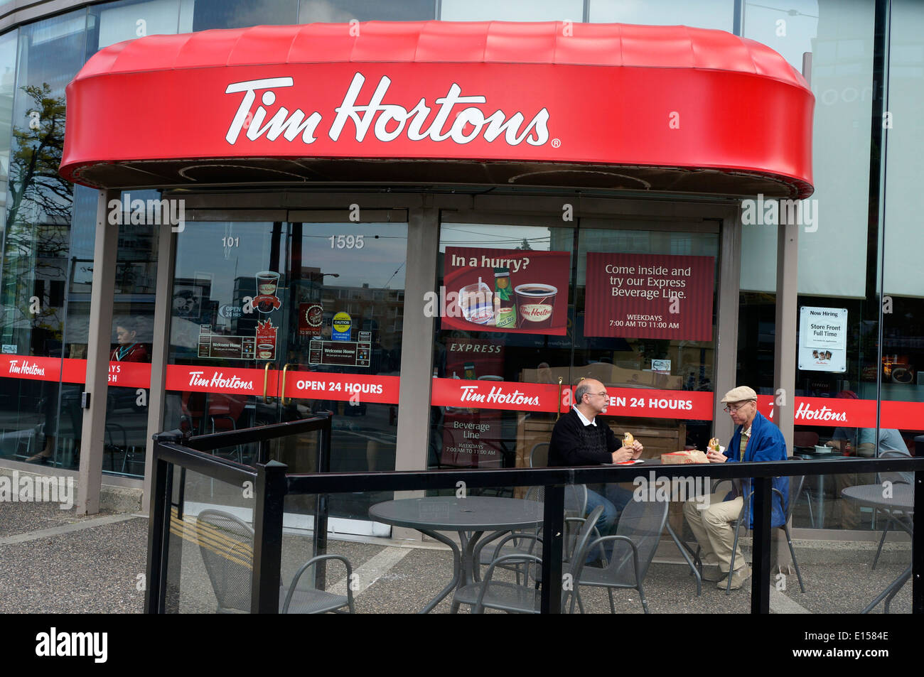 Due uomini di mangiare il pranzo a un Tim Hortons caffetteria e ristorante in Vancouver, BC, Canada Foto Stock