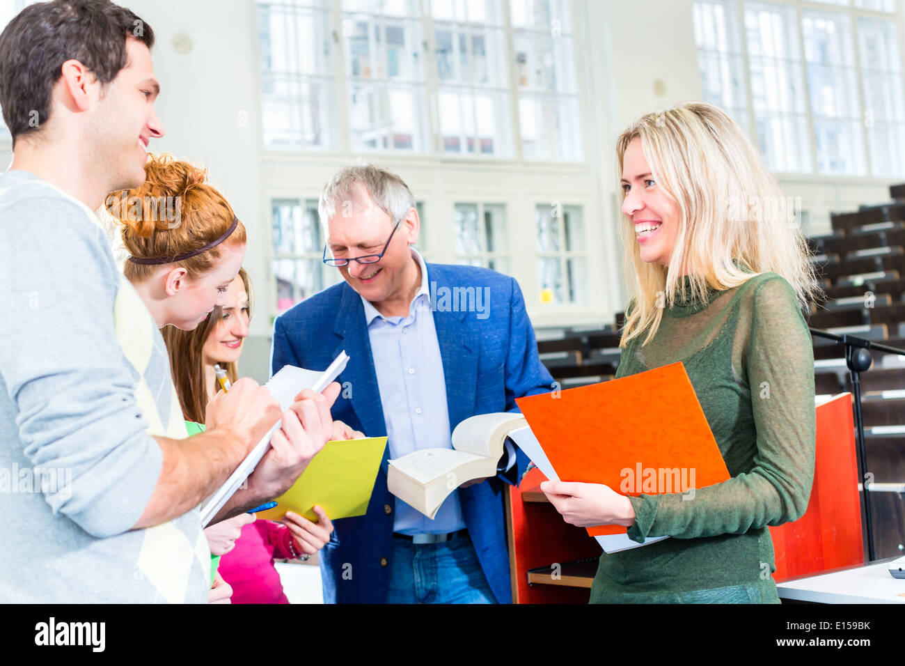 Gli studenti universitari che chiede il professor in auditorium universitari dopo la lezione Foto Stock