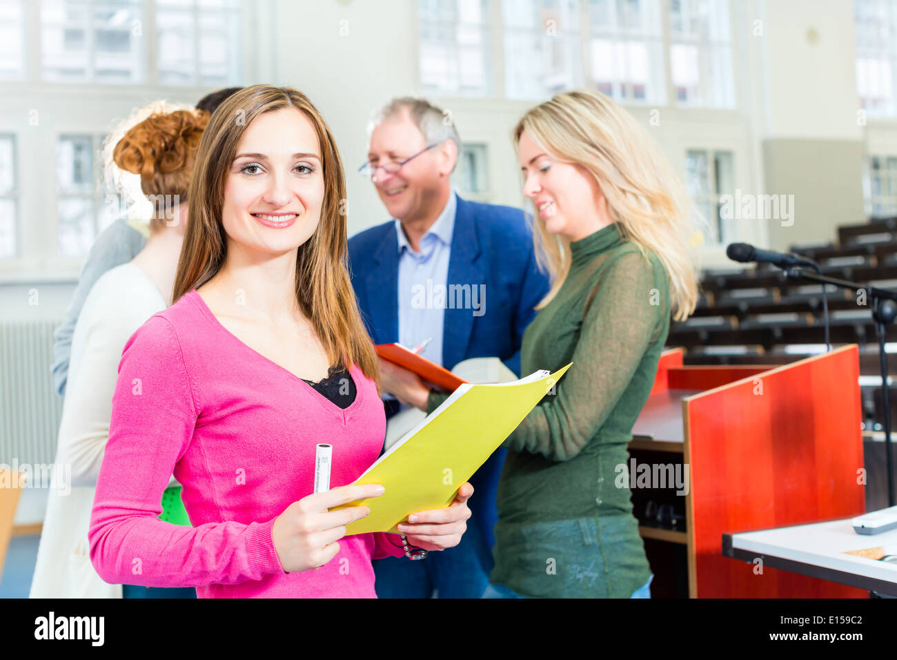 Gli studenti universitari che chiede il professor in auditorium universitari dopo la lezione Foto Stock