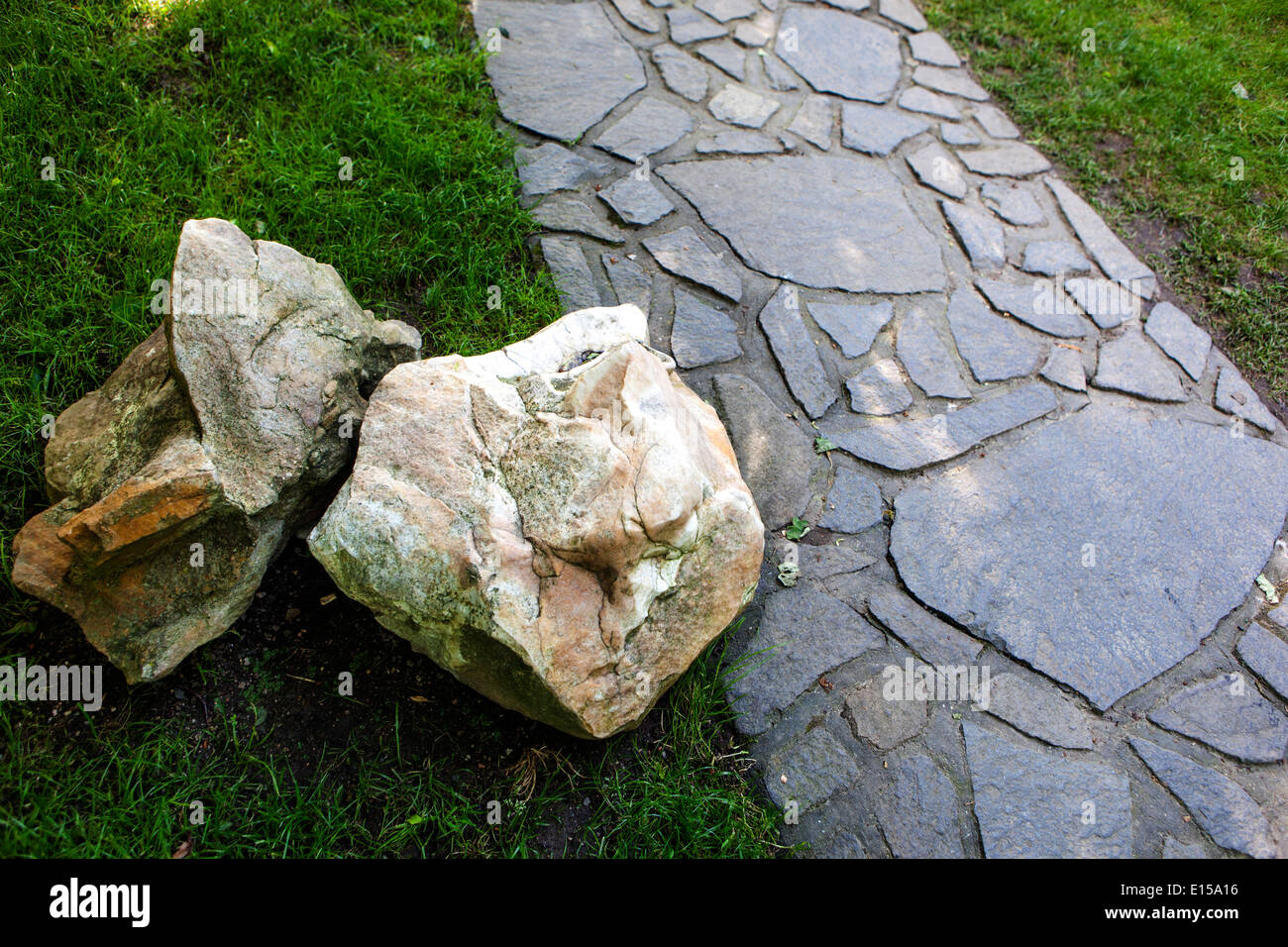 Percorso lastricato giardino e pietra in prato verde erboso Foto Stock