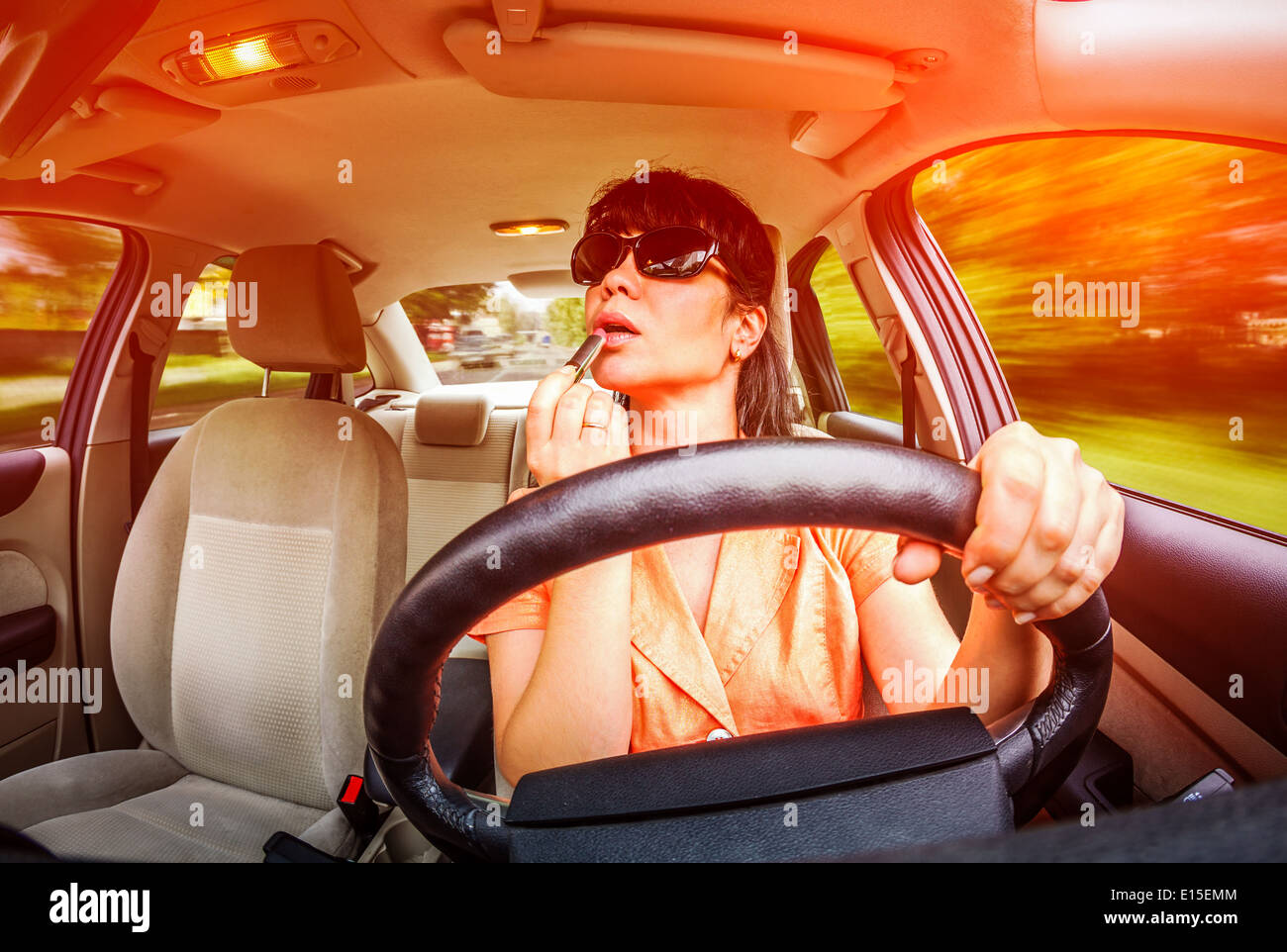 Le donne costituiscono le labbra al volante della vettura, non guarda sulla strada creando una situazione di emergenza. Foto Stock