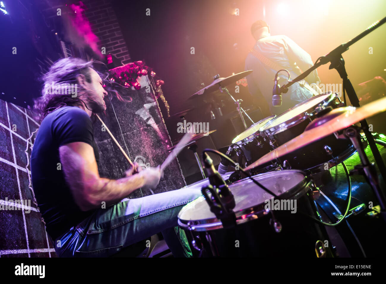 Il batterista (movimento sfocata) giocando sul drum set sul palco. Focus sul tamburo e microfono. Foto Stock