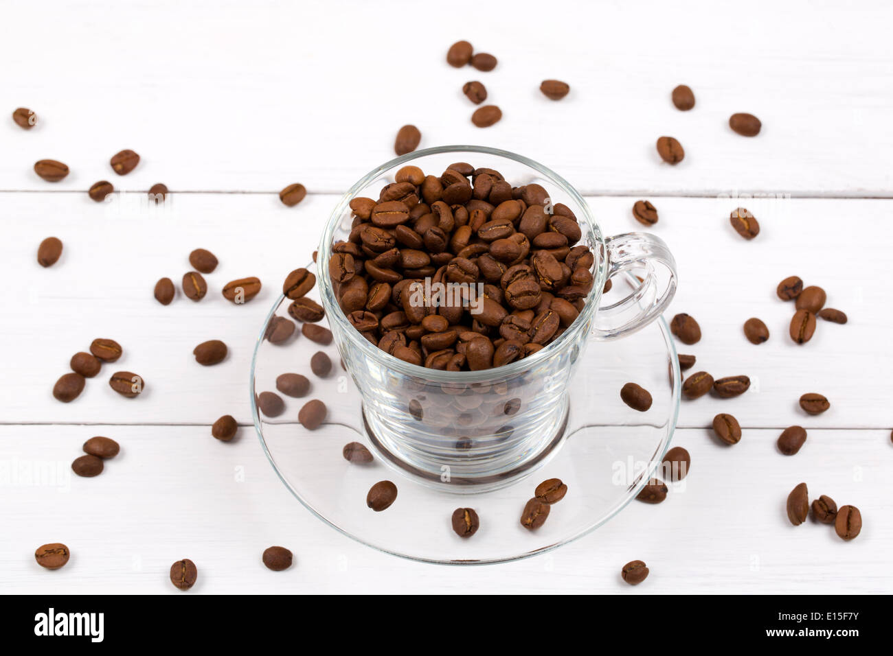 I chicchi di caffè nella tazza su uno sfondo di legno Foto Stock