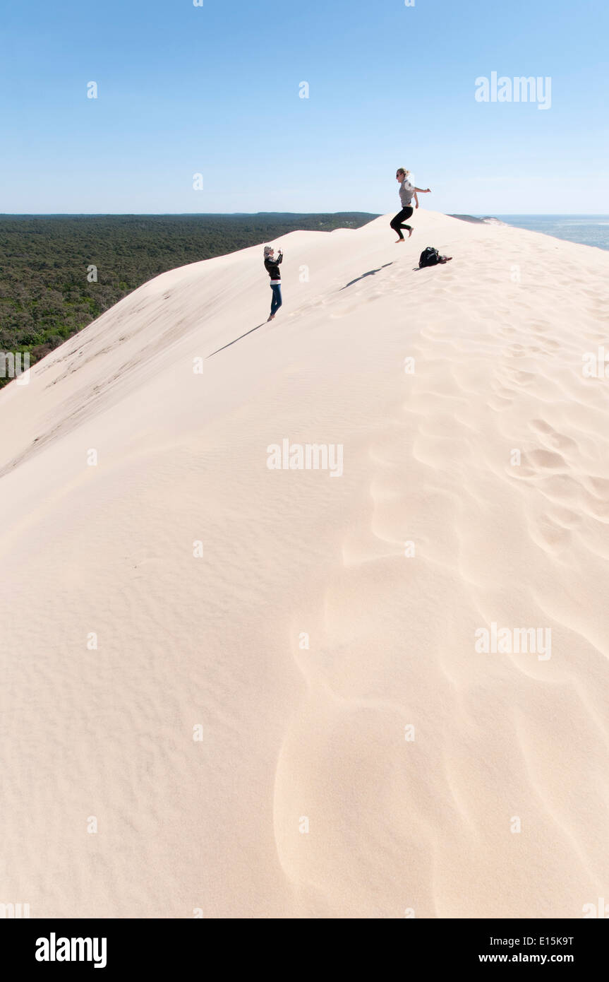 Francia, Gironde, Bassin d'Arcachon (Baia di Arcachon). Adolescente di prendere una fotografia di un amico il salto sulla Duna del Pyla Foto Stock