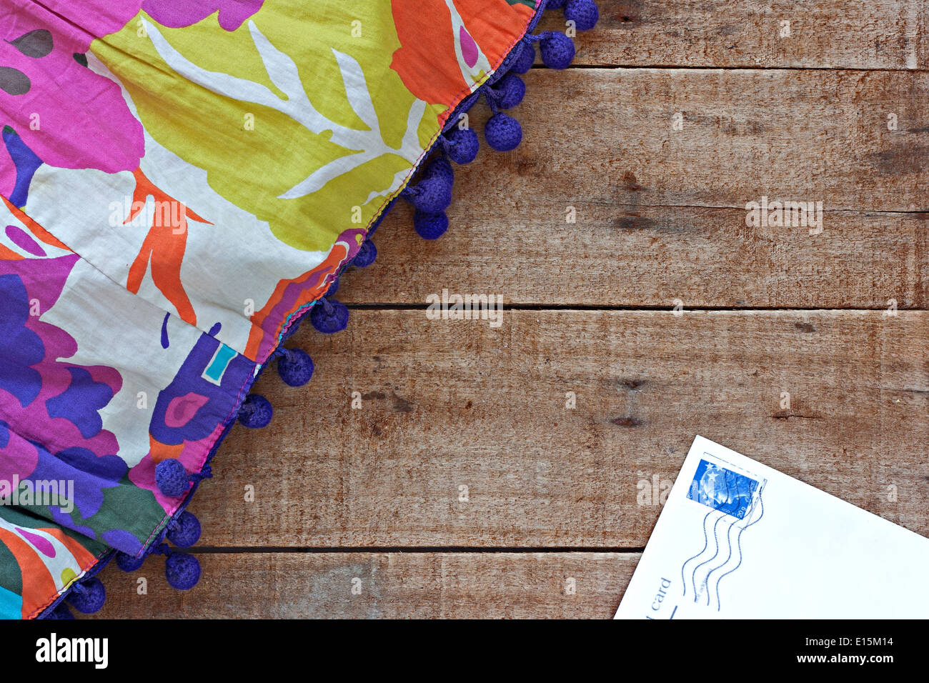 Womans colorati abiti estivi e cartolina su tavola in legno rustico Foto Stock