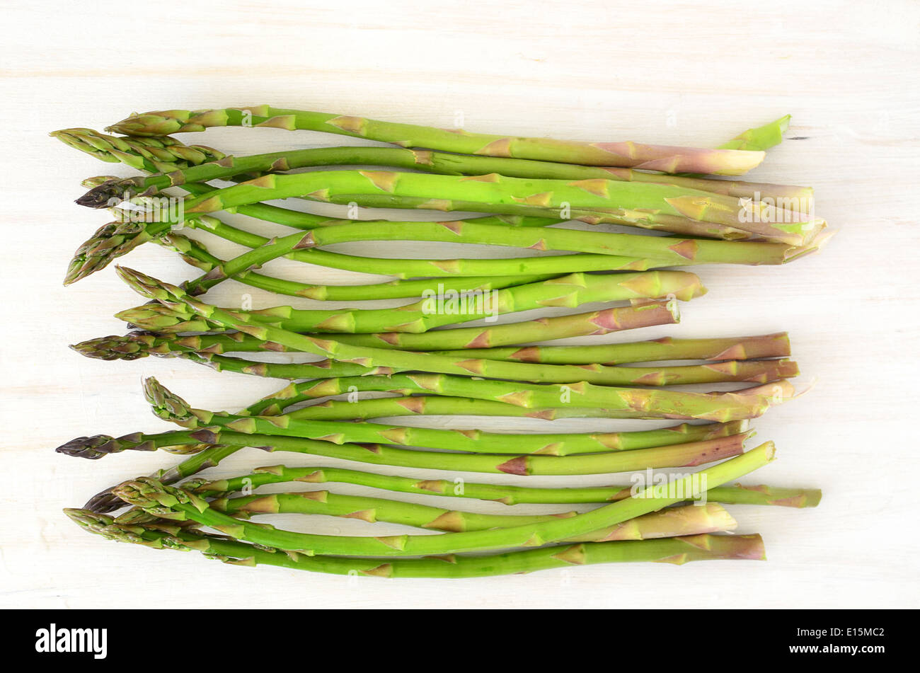 Giovani germogli di asparagi sul bianco rustico tagliere sfondo Foto Stock