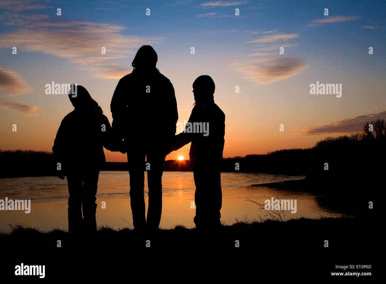 La madre e le figlie sul Danubio sotto le rovine di Devin in Slovacchia - silhouette Foto Stock