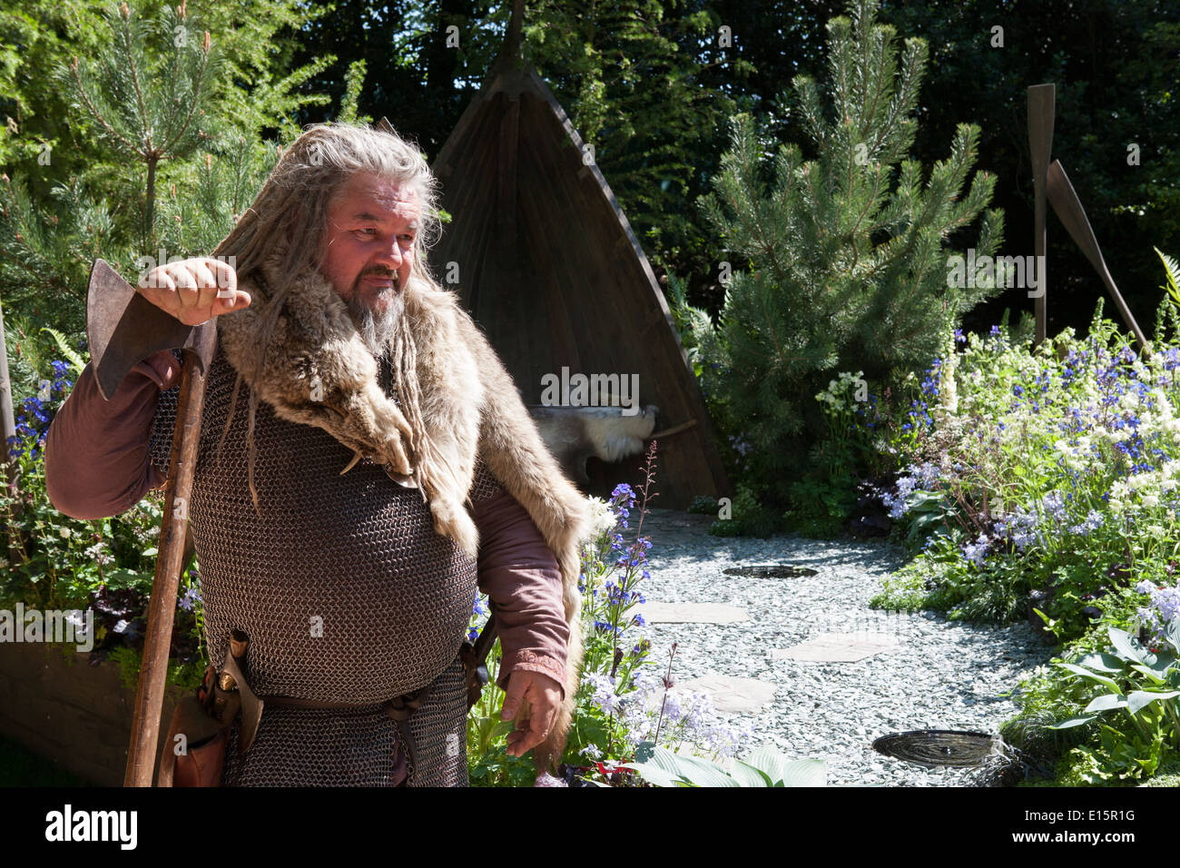 Ritratto di un vichingo con greggi che tengono un'ascia in un giardino Foto Stock