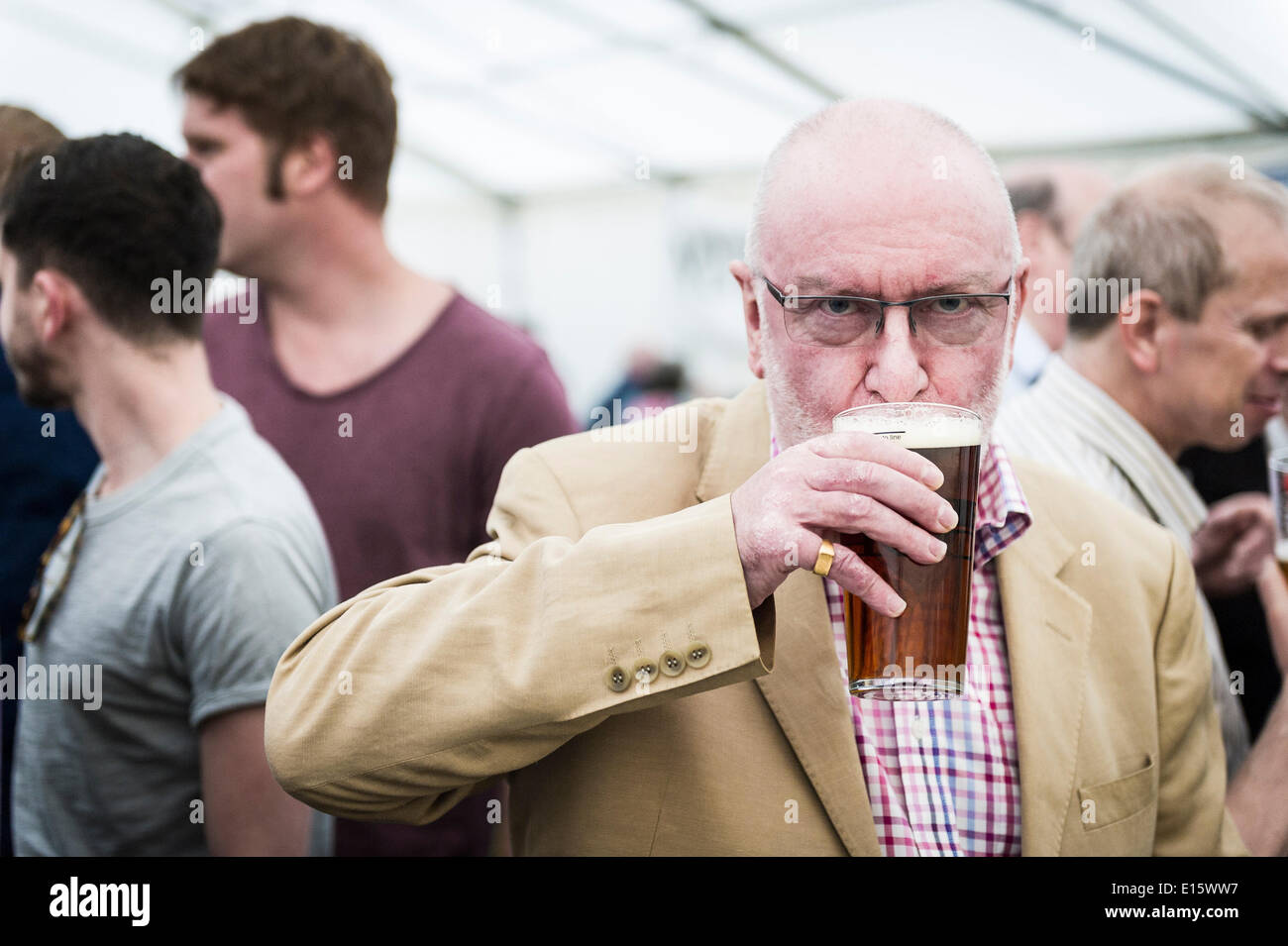 Stock, Essex. 23 Maggio, 2014. La prima pinta di birra viene degustato da una real ale fan per il giorno di apertura del cerchio del festival della birra, Essex più famosi pub festa della birra. Negli ultimi venti anni, il cerchio del festival della birra in Stock Village è diventato un evento annuale, disegno grave birra sorseggiando folk da lontano come in Norvegia e in Australia. Fotografo: Gordon Scammell/Alamy Live News Foto Stock