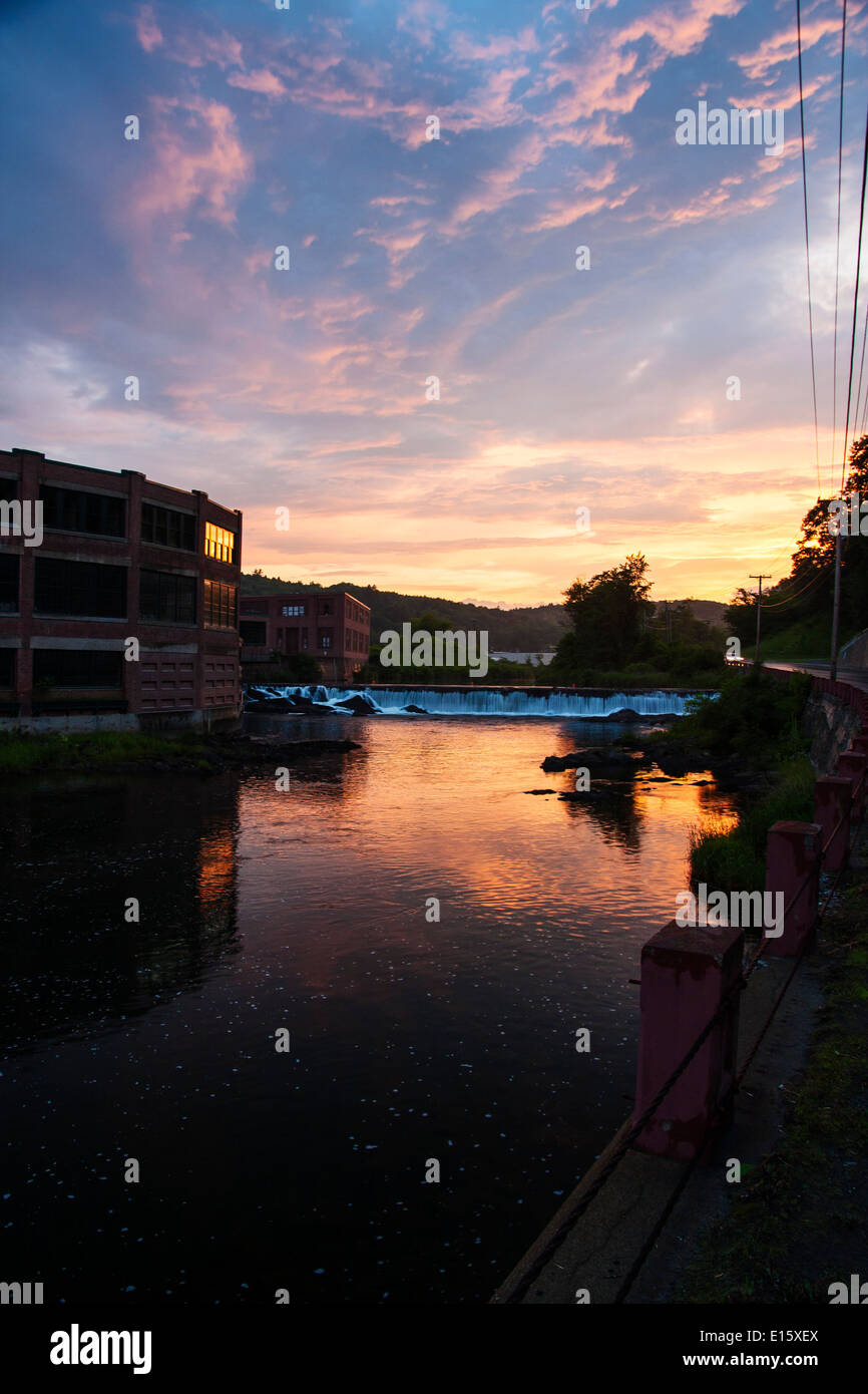 Springfield, Vermont, USA, il 24 giugno 2013, rosso fabbriche di mattoni lungo il fiume nero come il sole tramonta Foto Stock