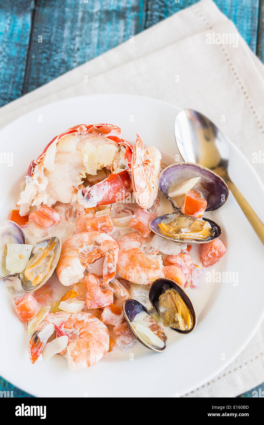 Stufato di pesce fatta con aragosta, granchi, gamberi e vongole cotte nel latte di cocco con pomodori e cipolle Foto Stock