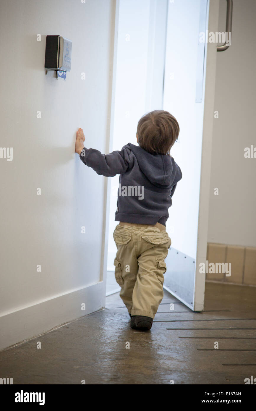 Boy utilizzando una chiave per aprire una porta Foto Stock