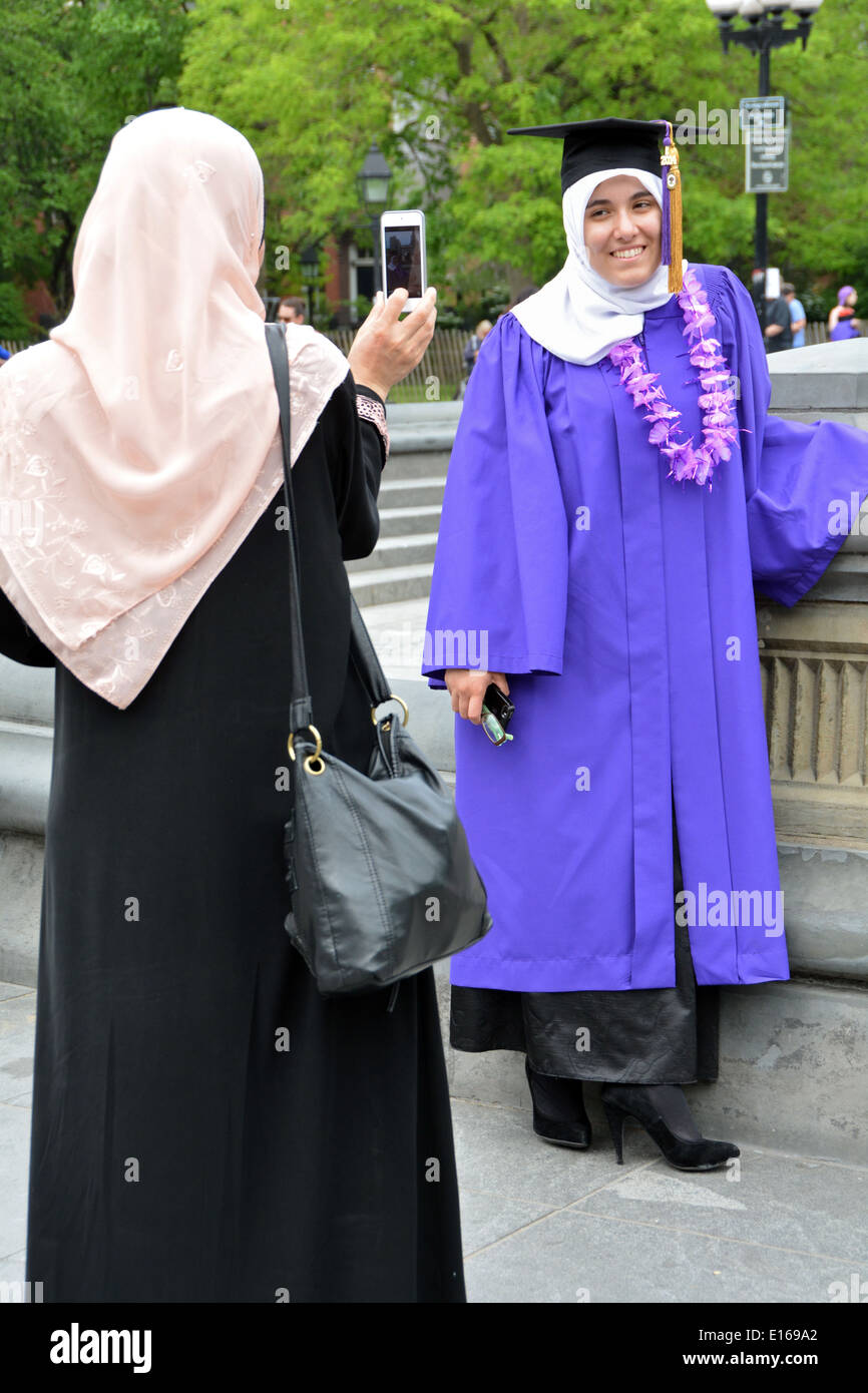 Un arabo musulmano studente in cap & vestaglia e sua madre per celebrare la graduazione da NYU nel Greenwich Village di New York City Foto Stock