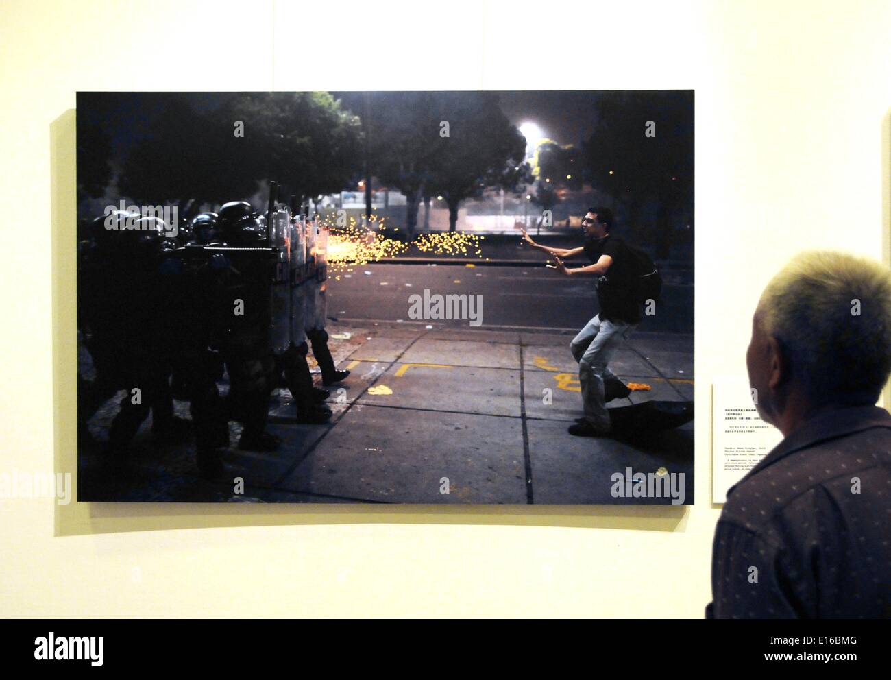 Pechino, Cina. Xxiv Maggio, 2014. Un visitatore visualizza la foto "affrontare con il Team di tiro' al decimo China International Press Photo Contest (CHIPP) vincente mostra fotografica a Pechino Capitale della Cina, 24 maggio 2014. La mostra, visualizzazione 229 foto vincitrici, dato dei calci fuori alla Cina Monumento Millenario di sabato. © Wang Zhen/Xinhua/Alamy Live News Foto Stock