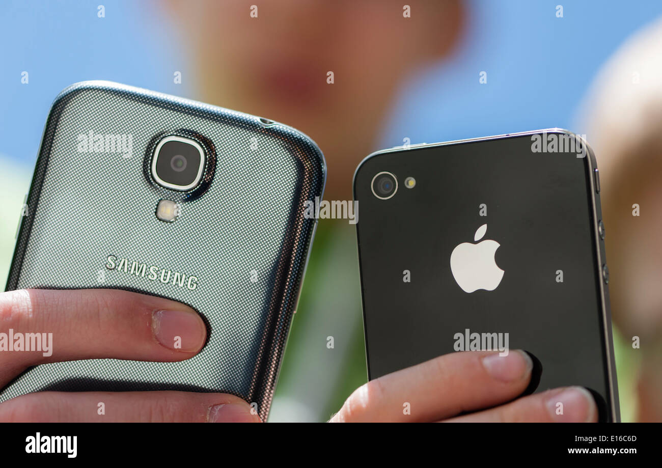 Due ragazzi sono in posa con il loro Samsung Galaxy S4 (sinistra) e l'iPhone  4 smartphone Foto stock - Alamy