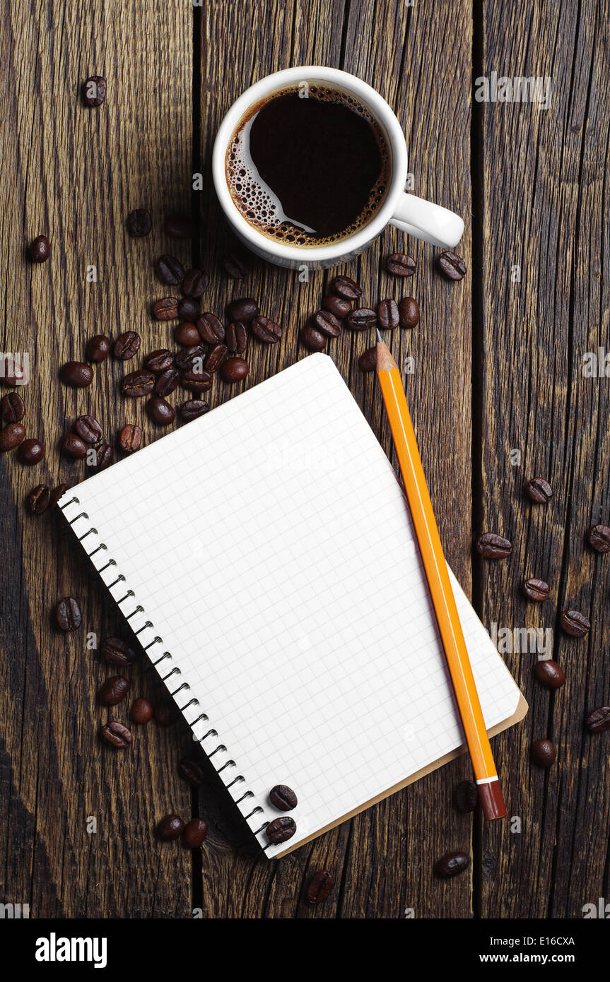 Tazza di caffè e blocco note su sfondo di legno Foto Stock