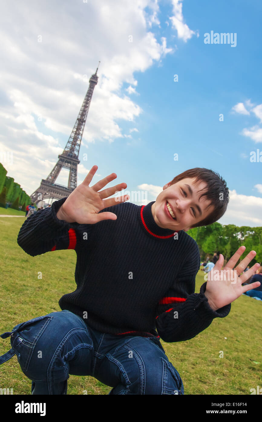 Adolescente ridendo, giocando e ingannare circa su Champ de Mars davanti alla Torre Eiffel (La Tour Eiffel) a Parigi Foto Stock
