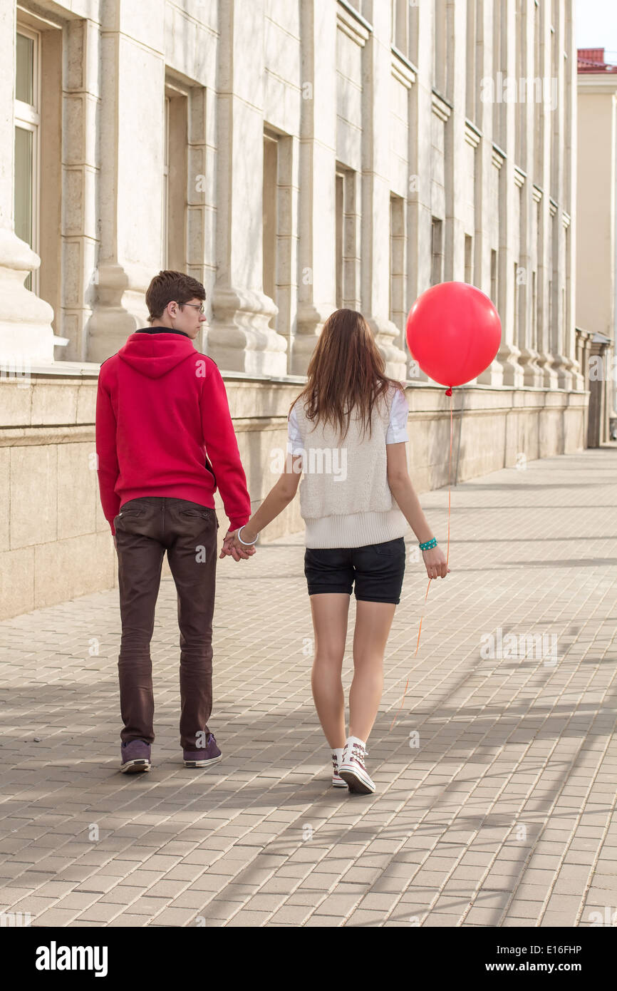 Moda giovane elegante giovane in amore in posa mattina su un vuoto che la strada della citta'. Tanga ragazza carina con bel uomo avente Foto Stock