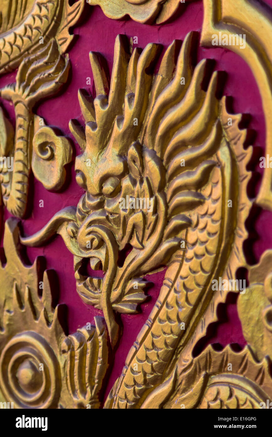 Golden Dragon testa sul rosso porta in legno Foto Stock