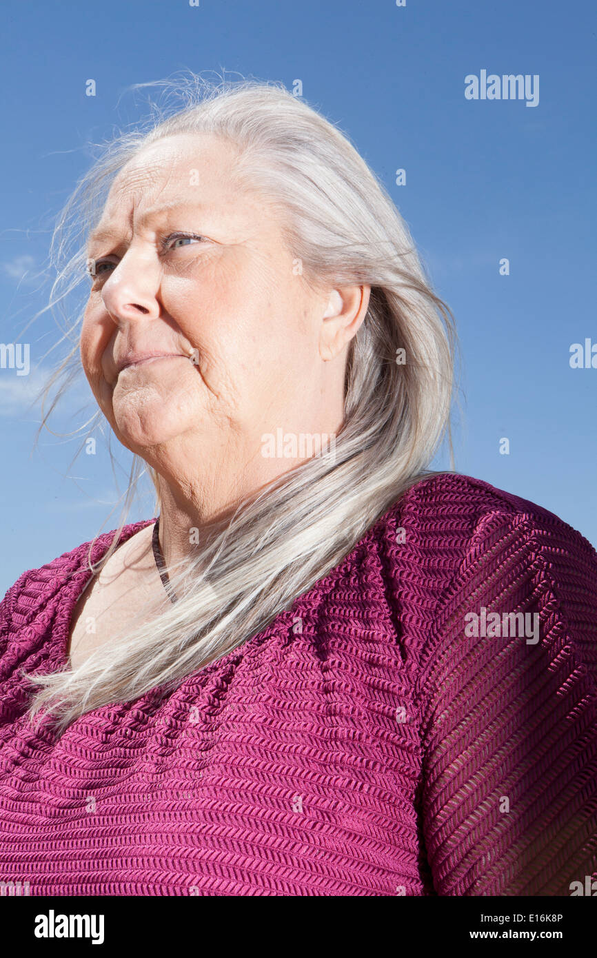 Ritratto di donna di mezza età in piedi contro il cielo blu Foto Stock