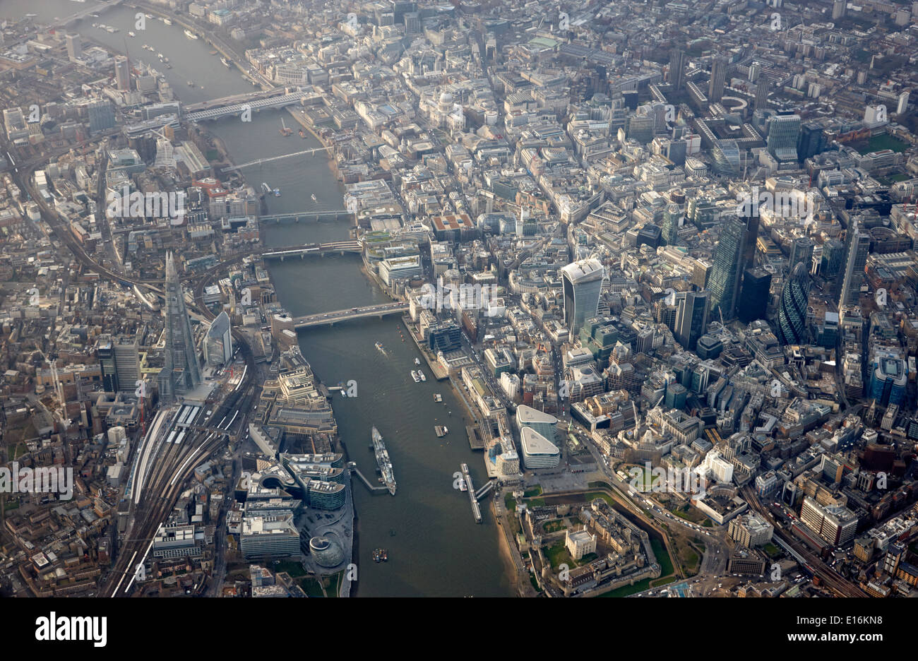 Vista aerea attraverso il finestrino per aerei guardando verso il basso sulla città di Londra il quartiere finanziario e il fiume Tamigi centro di London REGNO UNITO Foto Stock
