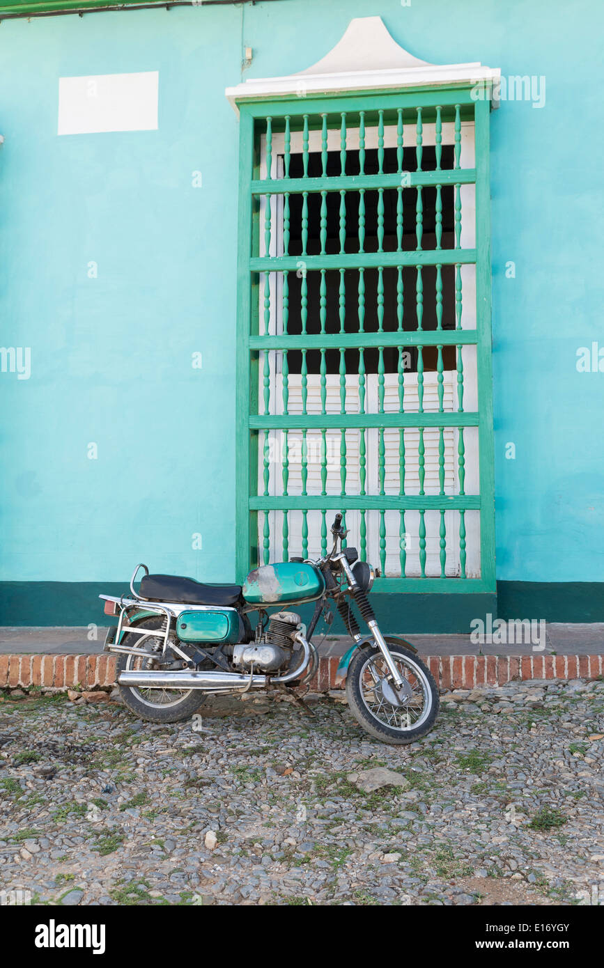 Vecchia motocicletta davanti a una parete con finestra, Trinidad, Cuba Foto Stock